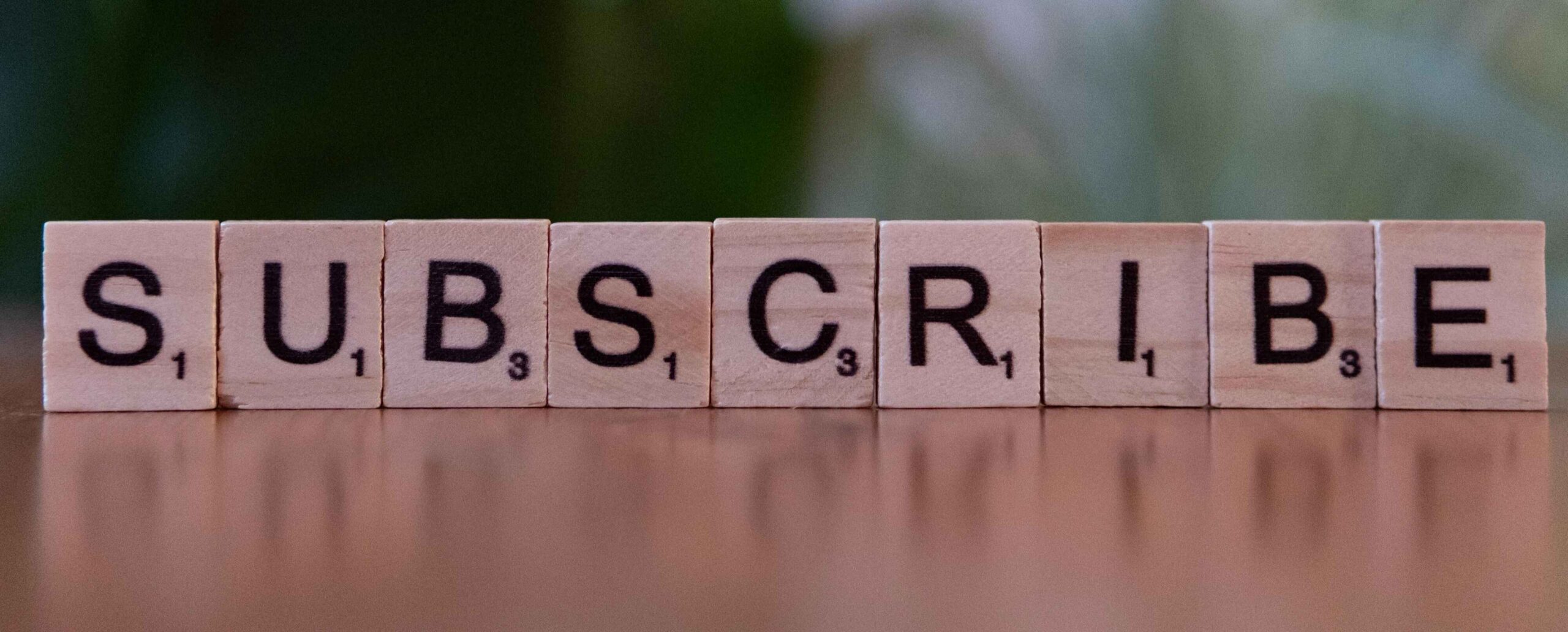 Holzklötze bilden das Wort „Subscribe“ als Aufforderung zur Anmeldung für den Newsletter